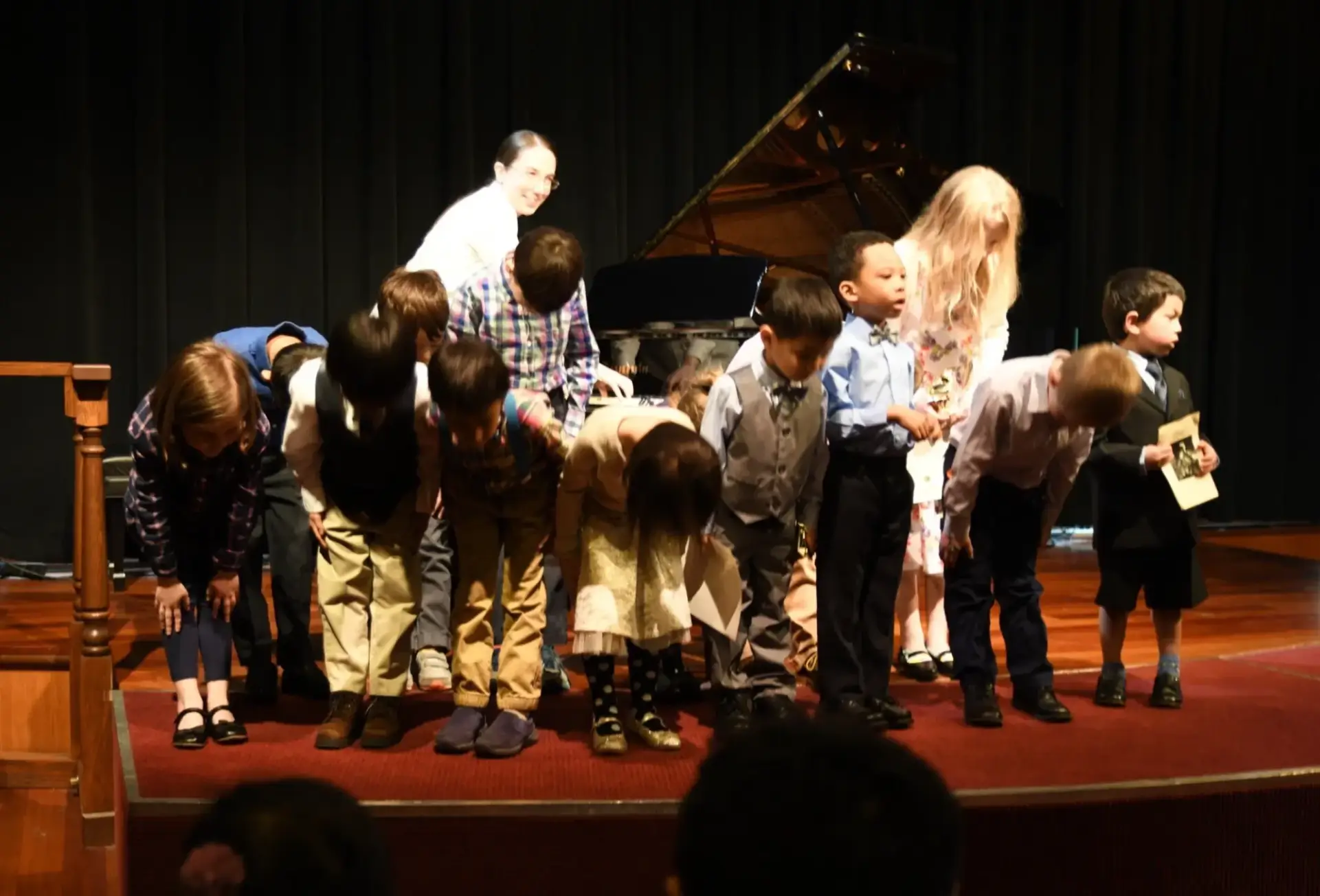 Suzuki piano students in Portland bowing together after group performance